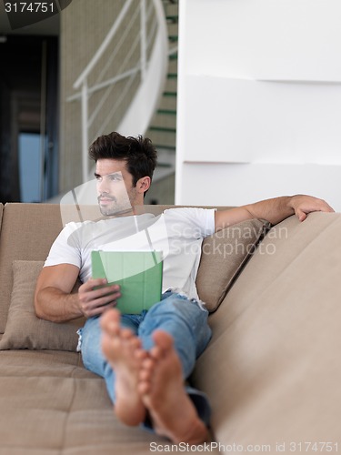 Image of man using tablet computer from home