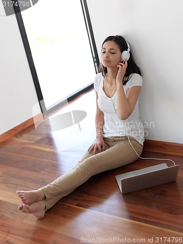 Image of relaxed young woman at home working on laptop computer