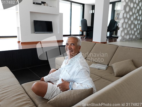 Image of Portrait of senior man relaxing in sofa