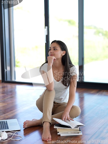 Image of relaxed young woman at home working on laptop computer