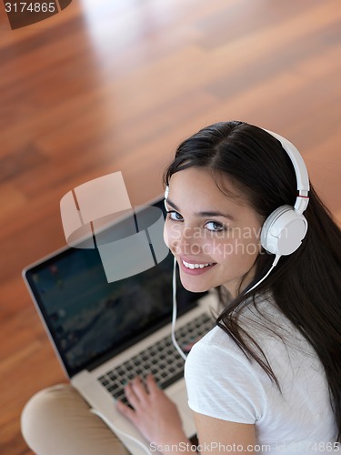 Image of relaxed young woman at home working on laptop computer