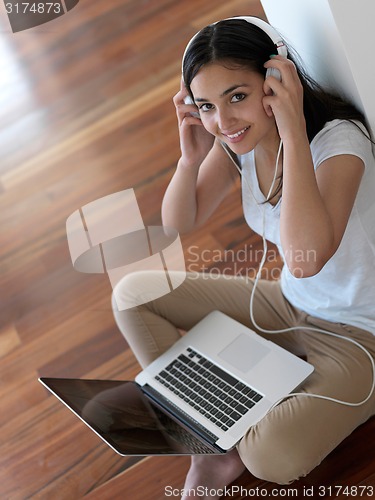 Image of relaxed young woman at home working on laptop computer