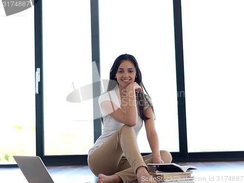 Image of relaxed young woman at home working on laptop computer
