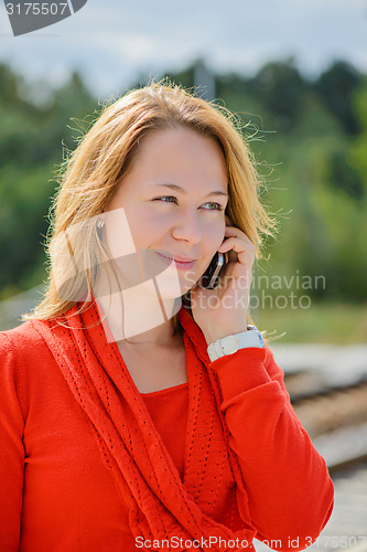 Image of Young beautiful girl talking on mobile phone