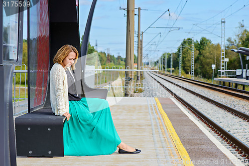 Image of Female sitting and waiting train on the platform 