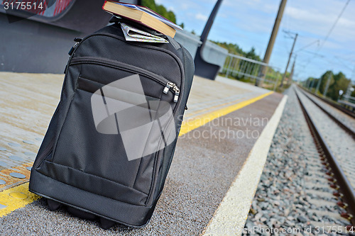 Image of Gray suitcase on the railway platform