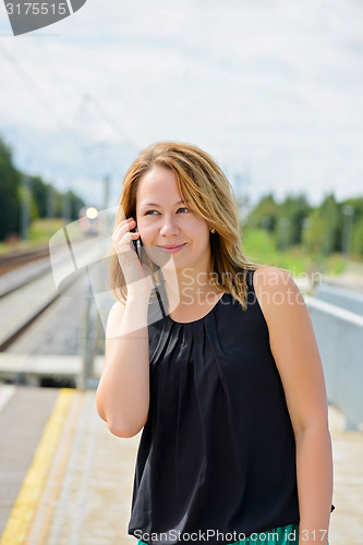 Image of Young beautiful female talking on mobile phone