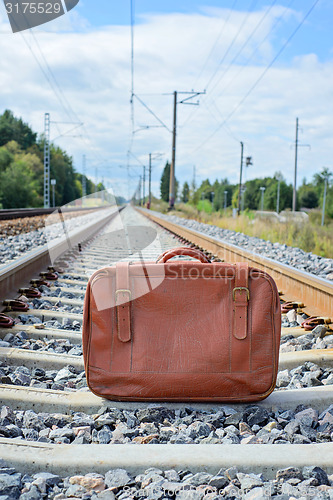 Image of Vintage brown suitcase on the railway