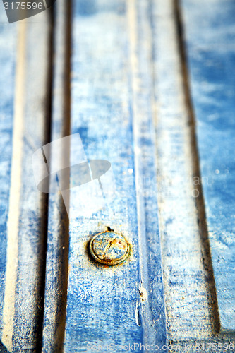 Image of stripped   in  wood door and rusty nail