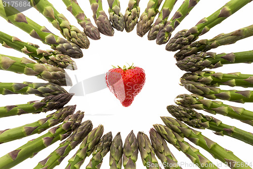 Image of Circle Of Asparagus Tips Pointing At Strawberry\r