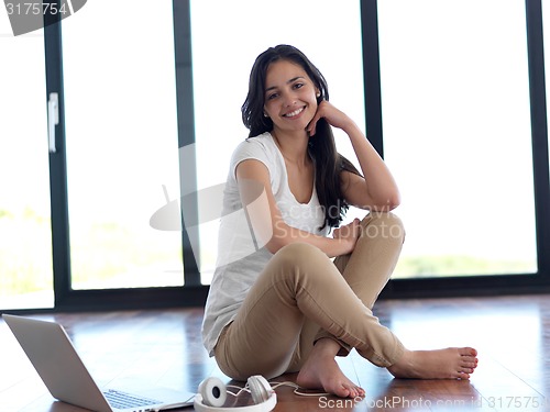 Image of relaxed young woman at home working on laptop computer
