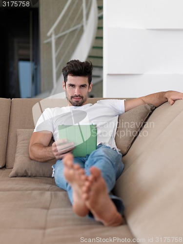 Image of man using tablet computer from home