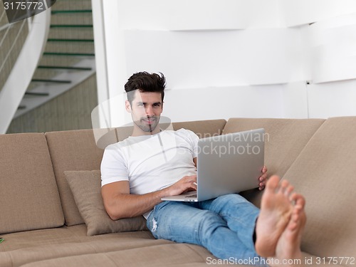 Image of Man Relaxing On Sofa With Laptop