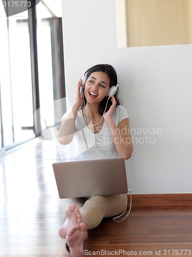 Image of relaxed young woman at home working on laptop computer