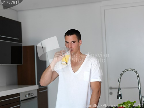 Image of man cooking at home preparing salad in kitchen