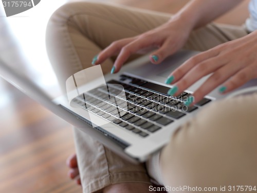 Image of relaxed young woman at home working on laptop computer