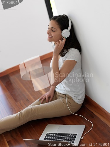 Image of relaxed young woman at home working on laptop computer