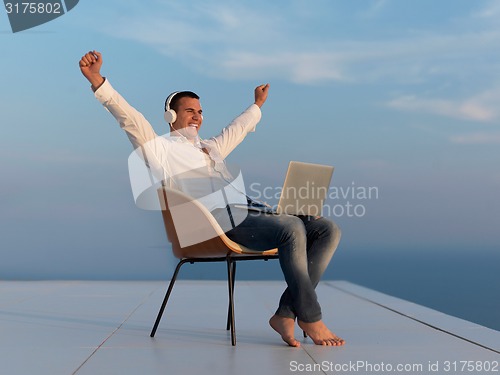 Image of relaxed young man at home on balcony