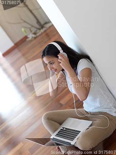 Image of relaxed young woman at home working on laptop computer
