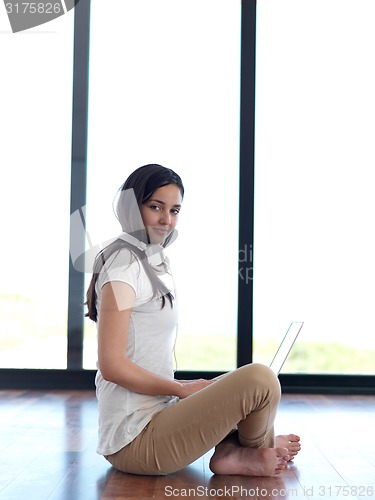 Image of relaxed young woman at home working on laptop computer