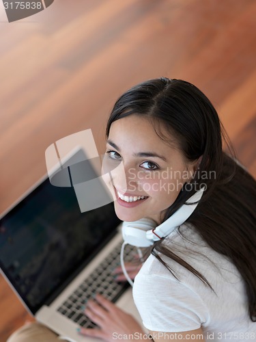 Image of relaxed young woman at home working on laptop computer