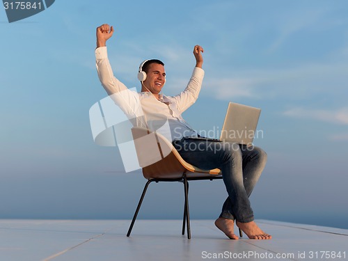 Image of relaxed young man at home on balcony