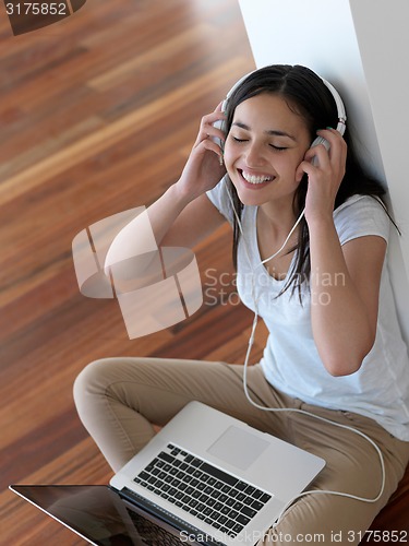 Image of relaxed young woman at home working on laptop computer