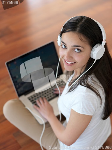 Image of relaxed young woman at home working on laptop computer