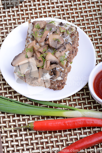 Image of mushroom salad on white plate and red pepper