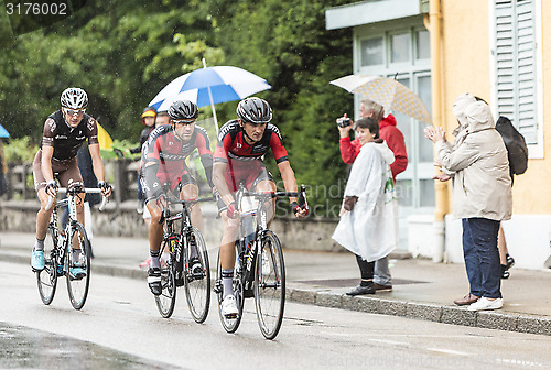 Image of Three Cyclists Riding in the Rain