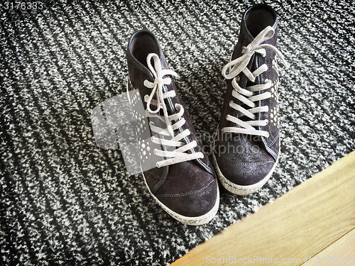 Image of Fashionable shoes on gray striped carpet