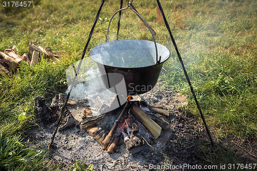 Image of Camp fire outdoors burning with pot