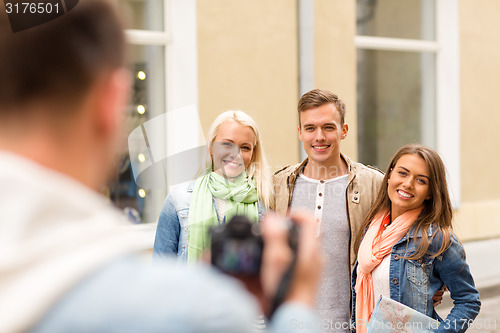 Image of group of smiling friends taking photo outdoors