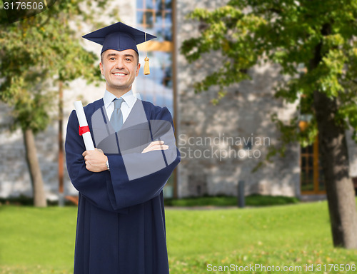 Image of smiling adult student in mortarboard with diploma