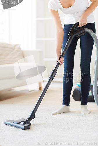 Image of close up of woman with vacuum cleaner at home