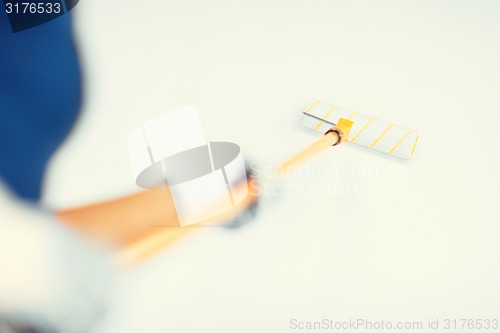 Image of woman with roller and paint colouring the wall