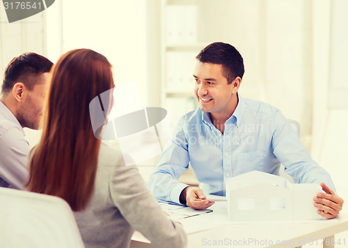 Image of couple looking at model of their house at office