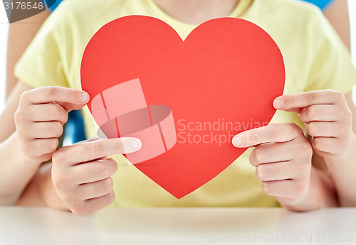 Image of close up of girl and mother holding red heart