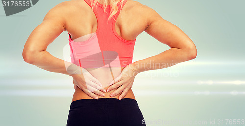 Image of close up of sporty woman touching her back