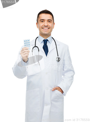 Image of smiling male doctor in white coat with tablets