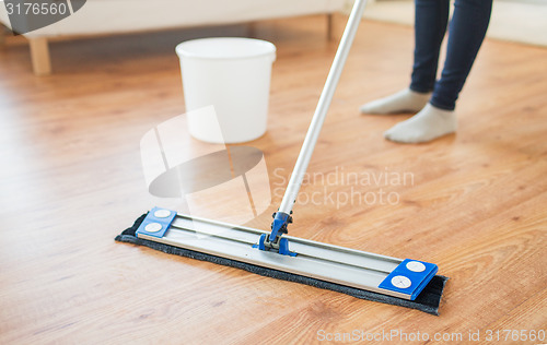 Image of close up of woman with mop cleaning floor at home