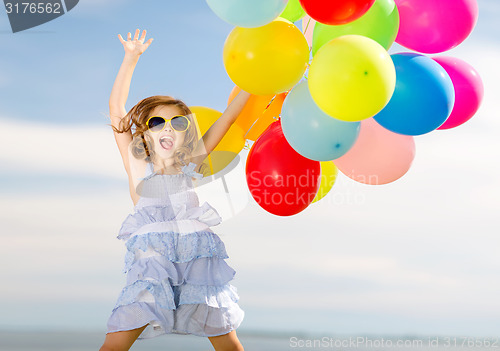 Image of happy jumping girl with colorful balloons