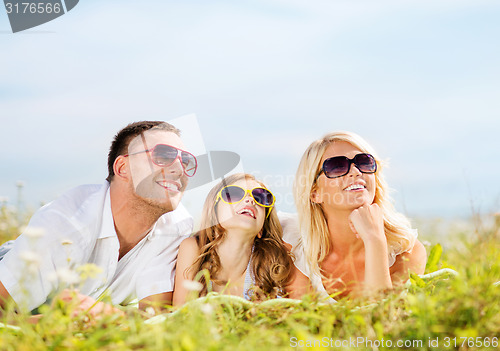 Image of happy family with blue sky and green grass