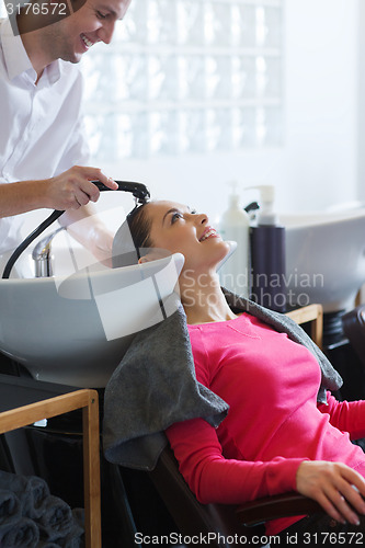 Image of happy young woman at hair salon