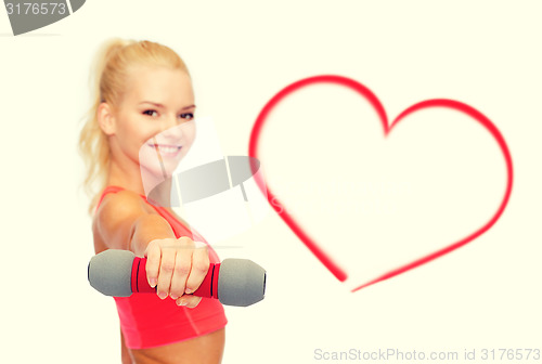 Image of smiling beautiful sporty woman with dumbbell