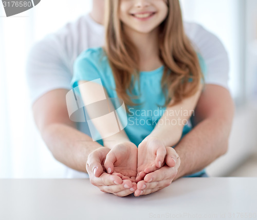 Image of close up of man and girl with cupped hands at home