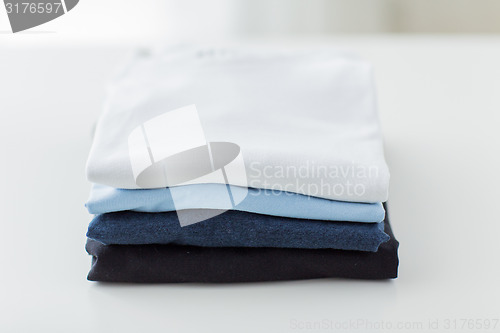 Image of close up of ironed and folded t-shirts on table