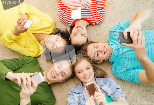 Image of group of smiling people lying down on floor