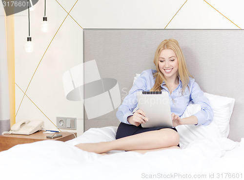 Image of happy businesswoman with tablet pc in hotel room