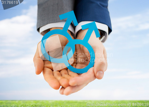 Image of close up of happy male gay couple with love symbol